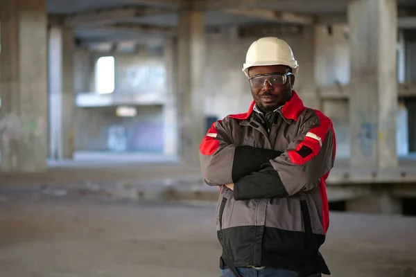 Afrikansk Amerikan Arbetare Vit Hatt Och Skyddsglasögon Står Byggområdet Tittar — Stockfoto