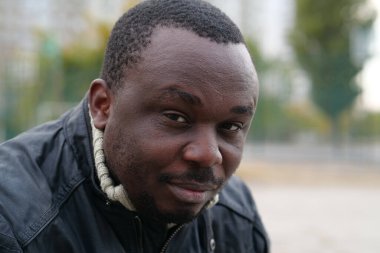 Nijeryalı Afrikalı Amerikalı adam kameraya bakıyor.