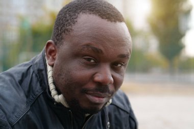 Nijeryalı Afrikalı Amerikalı adam kameraya bakıyor.