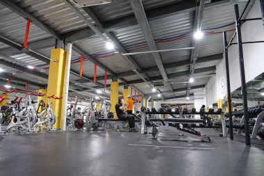 KYIV, UKRAINE, 2 Haziran 2023: Erkekler spor salonunda egzersiz yapıyor. Sporcular ağırlık egzersizleri yapıyor. Bir grup sporcu spor salonunda çalışıyor. Bilek güreşi ve kolluk kaldırma eğitimi. Formda vücut egzersizi.