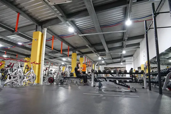 KYIV, UKRAINE, 2 Haziran 2023: Erkekler spor salonunda egzersiz yapıyor. Sporcular ağırlık egzersizleri yapıyor. Bir grup sporcu spor salonunda çalışıyor. Bilek güreşi ve kolluk kaldırma eğitimi. Formda vücut egzersizi.