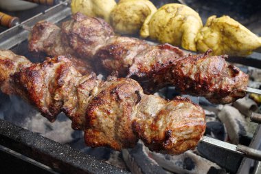 Lezzetli sıcak kebaplar. Şiş kebap ızgarada kızarır. Et, mangalda sıcak kömürde pişirilir, şiş şişte kızarır.