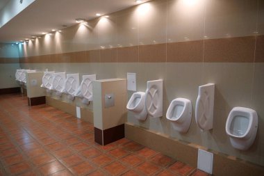 Large and clean public toilet with urinals clipart