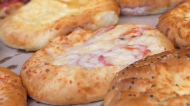 Pastane ürünleri tezgahta. Satıcı tezgahtan ekmek alır.