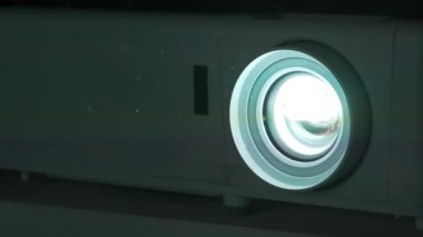 Ağır çekim. Sinema salonu. Projektör çalışıyor. Toz, ışık ışınlarında görülebilir.