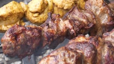 Yanmış kuru kebaplar. Sağlıksız yiyecekler. Kanserojen ve kötü kolesterollü yanmış et. Siyah kabuklu et tükürükler üzerinde döner