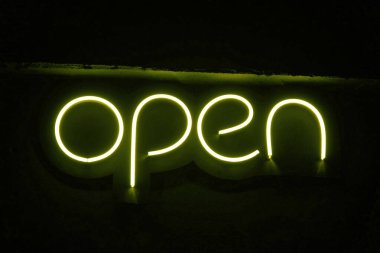 Üzerinde yazı olan sarı neon gece tabağı. Açık.