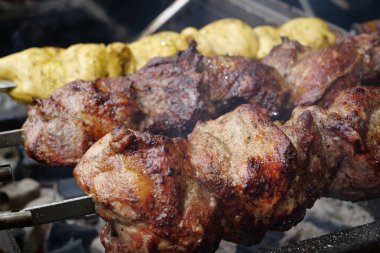 Şiş kebap ızgarada ızgara. Et, ızgarada sıcak kömürde pişirilir. Kızartma için şişte döner. Lezzetli sıcak et