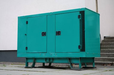 Yeşil dizel motorlu jeneratör binaya bağlı. Elektrik santrali bağımsız, tam teşekküllü bir güç üretim cihazı ve sistemidir. Elektrik enerjisinin kaynağı