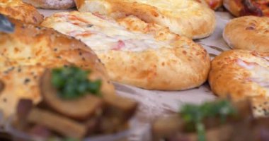 Pastane ürünleri tezgahta. Satıcı tezgahtaki çöreğe dokunur