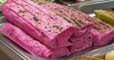 Tezgahta kırmızı hamurlu Shawarma var. Kırmızı hamurlu hazır shawarma.