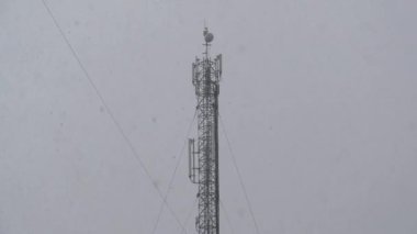 Kış karlı hava. Hücre kulesi ve yoğun kar yağışı. Şehirde yoğun kar yağışı var. Kar büyük taneler halinde düşüyor.