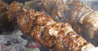Yağlı, sağlıksız, kısmen yanmış kolesterollü et. Barbeküde büyük şiş kebap. Et, ızgarada sıcak kömürde pişirilir.