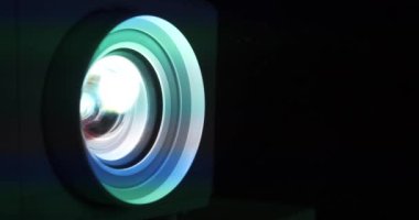 Sinema salonu. Projektör merceği çalışıyor. Film projektörle gösterilir. Çalışan projektörlerin lensleri renk değiştirir. Farklı renklerde ışık lenslerden geçer. Sinema 4K 60fps video