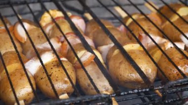Barbeküde patates ve domuz eti ızgarası. Domuz yağlı kızarmış patates. Patatesler ızgaradaki kızgın kömürde pişirilir.