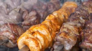 Lezzetli sıcak kebaplar. Şiş kebap ızgarada kızarır. Et, ızgarada sıcak kömürde pişirilir, kızartılmak için şişte döner. Sıcak kömürden çıkan duman. Etten yağ damlaları