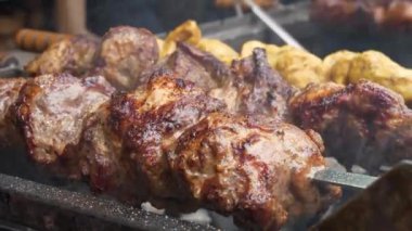 Lezzetli sıcak kebap. Büyük et parçalarıyla şiş kebap. Et, barbeküde sıcak kömürde pişirilir. Sıcak kömürden çıkan duman. Etten yağ damlaları