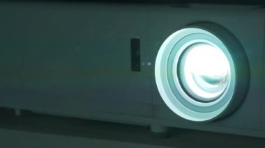 Projektör merceği çalışıyor. Sinema salonundaki projektörün yanındaki toz ışık huzmelerinde görülebilir.