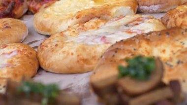 Pastane ürünleri tezgahta. Satıcı tezgaha çörek koyar.