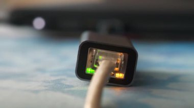 Ethernet kablo adaptörü. Yeşil LED ve yanıp sönen sarı LED 'li ethernet kablo adaptörü çalışıyor. Bilgisayara bağlı bir adaptör üzerinden internet kablosu, 4K 60fps yakınlaştırma videosu