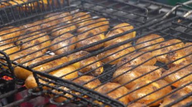 Kızarmış patates. Kömür mangalında patates kızartması. Patatesler ızgaradaki kızgın kömürde pişirilir.