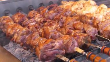 Şiş kebap ızgarada kızarır. Lezzetli sıcak kebaplar. Et, ızgarada sıcak kömürde pişirilir, kızartılmak için şişte döner. Sıcak kömürden çıkan duman. Etten yağ damlaları