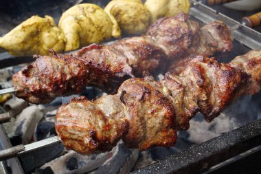 Lezzetli sıcak kebaplar. Şiş kebap ızgarada kızarır. Et, mangalda sıcak kömürde pişirilir, şiş şişte kızarır.