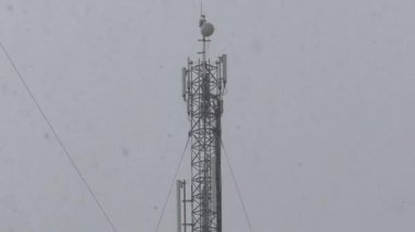 Kış karlı hava. Hücre kulesi ve yoğun kar yağışı. Şehirde yoğun kar yağışı var. Kar büyük taneler halinde düşüyor.