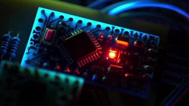 Elektronik teftiş. Yanıp sönen ultraviyole ışıkta yanan kırmızı LED ampullü elektronik devre. Elektronik bileşenleri güç kaynağına bağlı olan mikro devre. Mikro devre, rezistanslar
