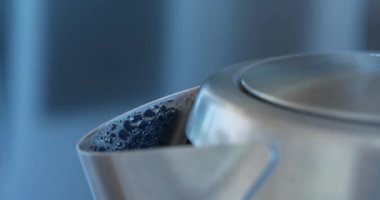 Su ısıtıcıda kaynıyor. Tencere dibin kara seninki benden kara. Buhar metal çaydanlıktan fışkırıyor. Çaydanlık suyu 100 santigrat dereceye ısıttı. Buhar ve buhar oluşumu, su damlaları.