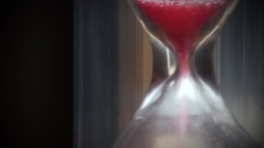Kum saatindeki kırmızı kum. Zaman ters yönde, ters yönde akar. Zaman her şeyi iyileştirir. Zaman en büyük şifa kaynağıdır. Zaman harikalar yaratır. 4K 60fps makro çekim ters zaman videosu
