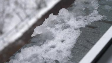 Eriyen kar pencere pervazında yatıyor. Pencereden görüntüle