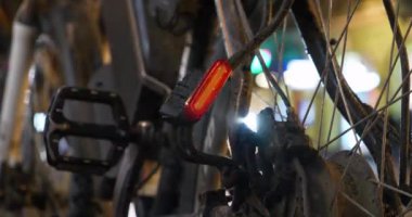 Bisiklette yanıp sönen kırmızı lamba, yolun yakınındaki bir otoparkta duruyor.