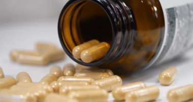 Erkekler için vitaminli kapsüller ve masada açık bir kavanoz var.