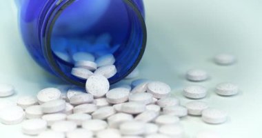 Masada besin takviyeleri için küçük kırmızı noktalı beyaz tabletler ve mavi kavanoz var. Aşırı doz teması. Gerçekte bunlar krom pikolinat tabletleridir. Sinema 4K 60 fps sinema efektli video