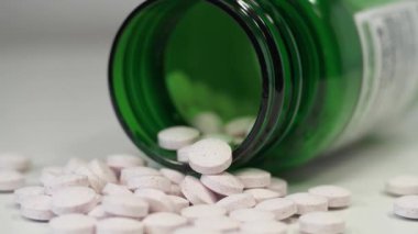 Masada küçük pembe noktalı beyaz tabletler ve besin takviyeleri için yeşil kaplar var. Bunlar krom pikolinat tabletleri.