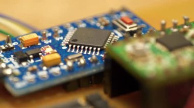 Elektronik tamir. Elektronik bileşenleri güç kaynağına bağlı olan mikro devre. Yanan kırmızı LED ampullü küçük bir elektronik devre. Mikro devre, rezistanslar ve çipler. Stepper motor sürücüsü