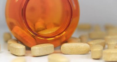 Masanın üzerinde büyük tabletler ve turuncu plastik kavanoz var. Zehirlenme ya da aşırı doz teması. Yüksek dozlar ve yan etkiler. İlaç ve gıda katkı maddesi endüstrisi. Sinema 4K 60fps video