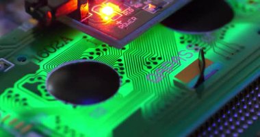 Elektronik tamir. Güç kaynağına bağlı elektronik bileşenleri olan yeşil bir mikro devre. Sinema 4K 60fps eğik görüntü