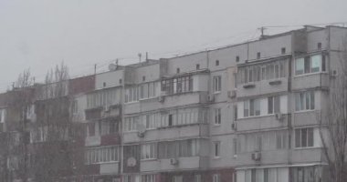 Kış karlı hava. Şehirde yoğun kar yağışı var. Kar büyük taneler halinde yağıyor. Sinema 4K 60fps Uzaklaştırma Görüntüsü