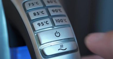 Tencere dibin kara seninki benden kara. Ayarlanabilir su ısıtma ısısıyla elektrikli su ısıtıcısını açıp kapatmak. Adam su ısıtıcısını açıp kapatıyor.