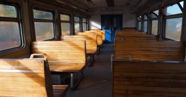 Slow Motion boş tren vagonu insanlar olmadan ilerliyor. Banliyö treninin boş vagonunda tahta koltuklar. Sinema 4K Yavaş Hareket videosu