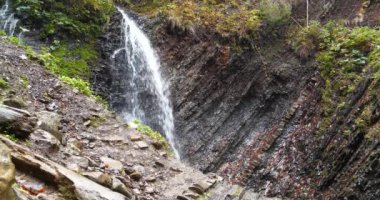 Küçük şelale ve jeolojik dağ vahşi doğada katlanır. Sinema 4K 60fps video