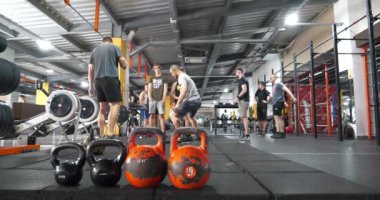 KYIV, UKRAINE, 2 Haziran 2023: Spor salonunda spor yapan bir grup sporcu. Spor salonunda egzersiz yapan güçlü adamlar. Sporcular ağırlık egzersizleri yapıyor. Kol kaldırma antrenmanı. Formda vücut egzersizi.