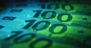 Ultraviyole ışık altında 100 Euro. Avro banknotlarındaki güvenlik işaretleri ve unsurları ultraviyole ışık altında parlıyor
