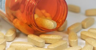 Masaya dağılmış büyük sarı tabletler ve turuncu kavanozu aç. Gerçekte bunlar 1 gram dozajında C vitamini haplarıdır.