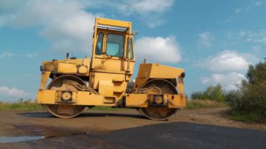 Yol silindiri işini bitirdi ve dinleniyor. Yol silindiri - Toprak, çakıl, beton veya asfalt yapımında kullanılan sıkıştırıcı tipi mühendislik aracı