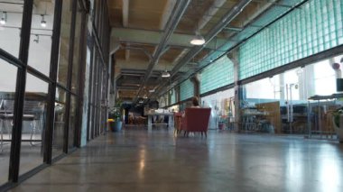 KYIV, UKRAINE, 21 AĞUSTOS 2022: Eski fabrika atölyesindeki çalışma alanındaki insanlar. Ortak çalışma - farklı şirketlerdeki işçilerin aynı ofisi paylaştığı, maliyet tasarruflarına olanak sağlayan düzenleme