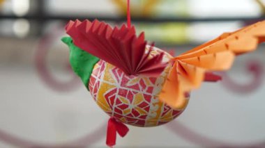 Plastikten, kağıttan ve boyanmış paskalya yumurtasından yapılmış kuş figürü ipe asılır ve döner.