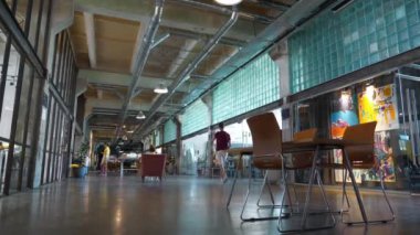 UKRAINE, KYIV, AĞUSTOS 22, 2022: fabrikanın eski atölyesindeki insanlar. Ortak çalışma - farklı şirketlerdeki işçilerin aynı ofisi paylaştığı, maliyet tasarruflarına olanak sağlayan düzenleme